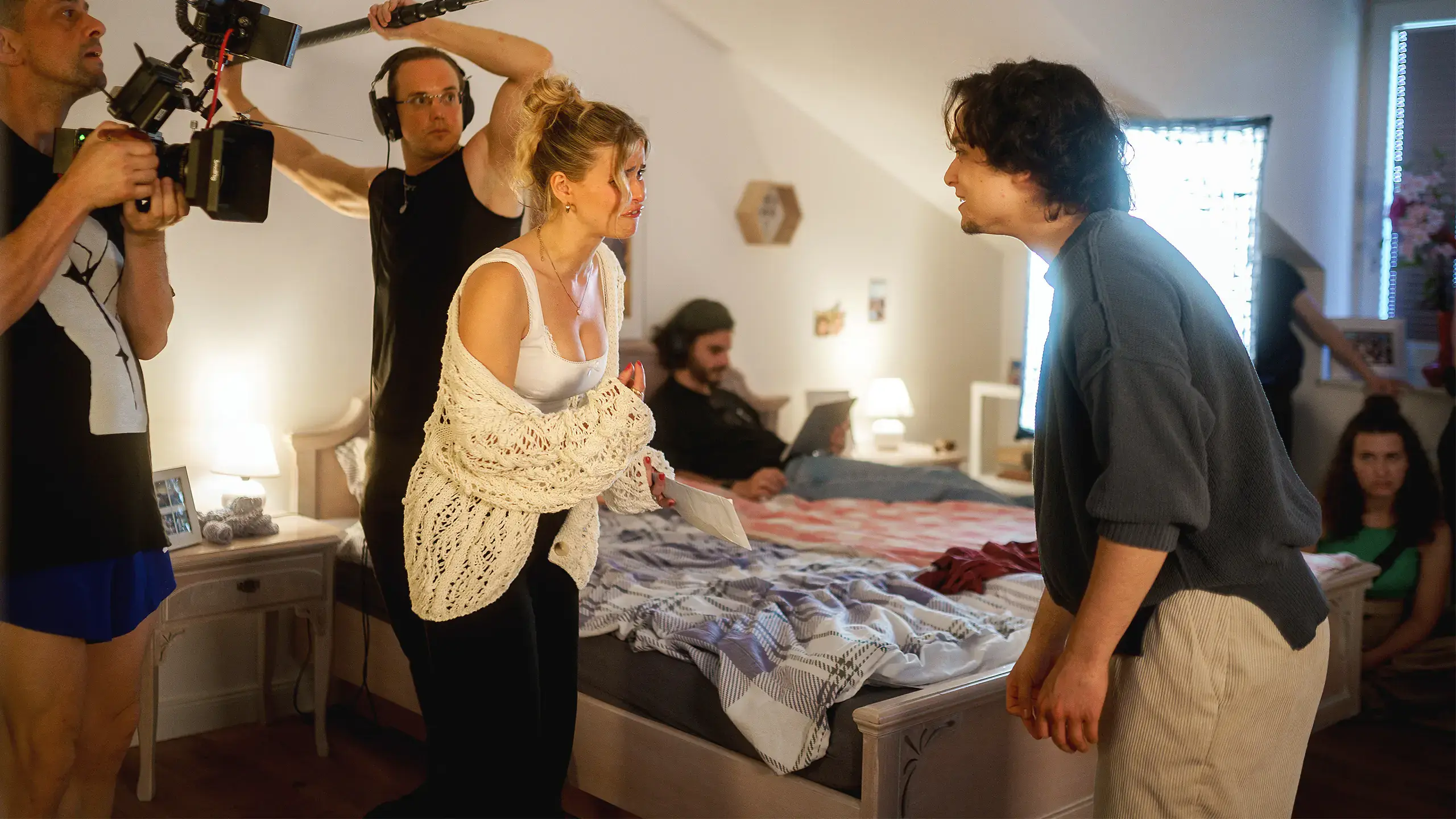 Filmcrew mit Kamera und Tonangel bei Dreharbeiten in einem Schlafzimmer-Set der IAF