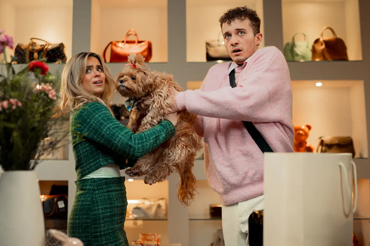 Zwei Darsteller mit Hündchen und erschrockenem Blick in einer Handtaschen-Boutique, Standbild aus dem IAF Abschlussfilm Rich or Broke 2025