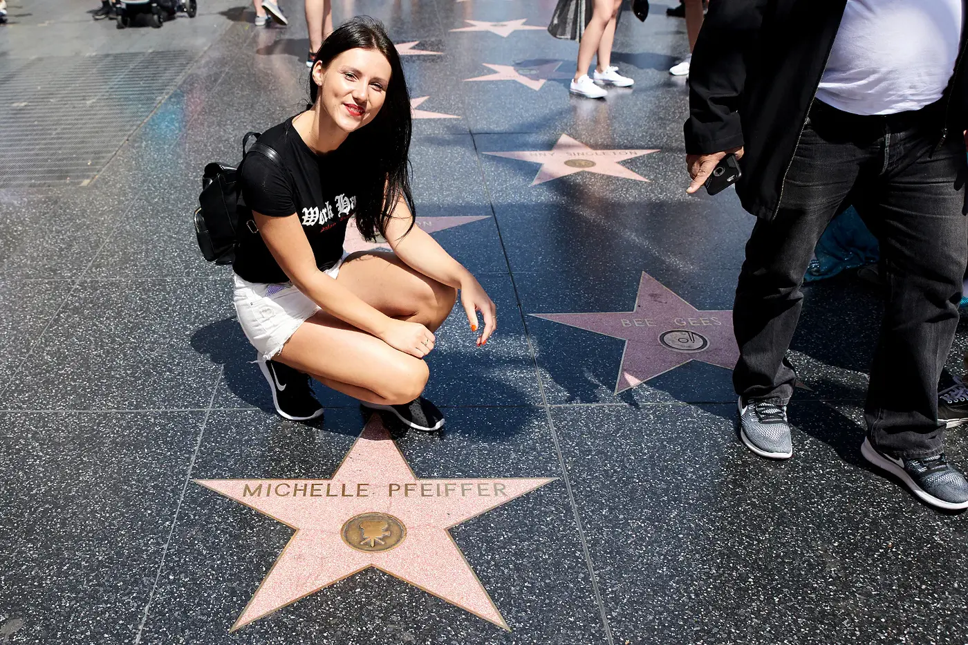 Studentin kniet am Stern von Michelle Pfeiffer auf dem Walk of Fame, Los Angeles Studienfahrt der IAF 2017